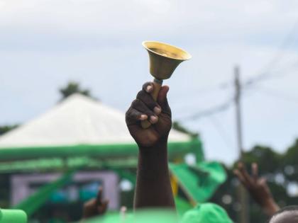 A Jamaica Labour Party supporter rings a bell at the party's 81st Annual Conference at the National Arena in Kingston on November 24, 2024.