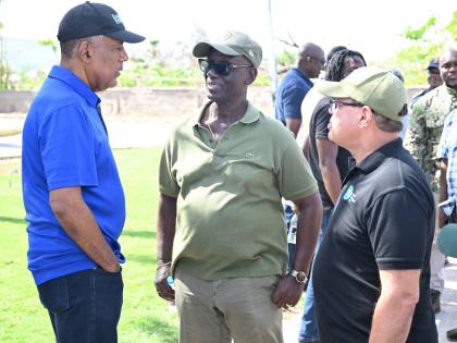 Minister of Local Government and Community Development, Desmond McKenzie (centre), converses with President and Chief Executive Officer of the Port Authority of Jamaica, Professor Gordon Shirley (left), and Chairman of the Tourism Product Development Compa