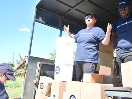 Volunteers from Canadian-based humanitarian group, GlobalMedic, demonstrate the use of the water-purification bucket while distributing hygiene kits to residents of Frome, Westmoreland, on November 27.