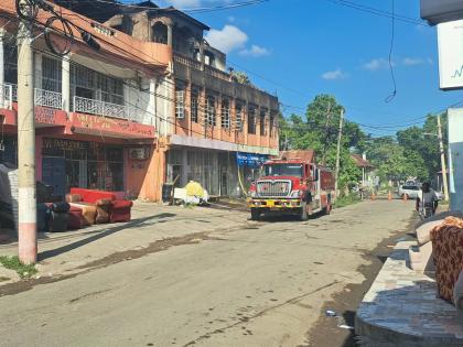 A fire truck at a building located at the corner of Williams Street and Young Street in Spanish Town, St Catherine that was damaged by a blaze on December 6, 2025.