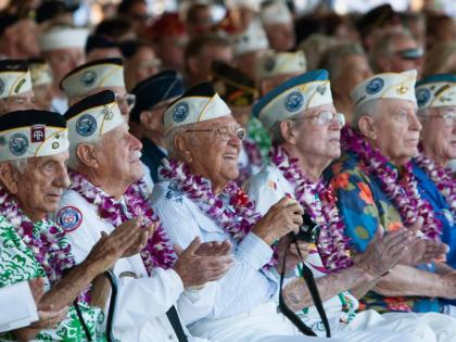 Pearl Harbor survivors watch a vintage WWII airplane fly over Pearl Harbor at the ceremony commemorating the 72nd anniversary of the attack on Pearl Harbor, in 2013, in Honolulu.