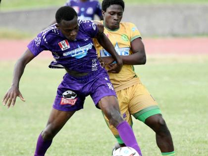 Kingston College’s Kamaul Patterson (left) shields the ball from Richardo Lewis of St Jago High School during the Walker Cup KO match at Stadium East yesterday. KC won the encounter 4-1.