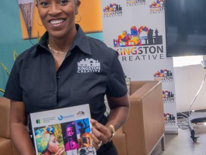 Co-founder and Executive Director of Kingston Creative and Co-chair of the Cultural and Creative Industries Alliance of Jamaica, Andrea Dempster Chung, holds up a copy of the 2025 Cultural and Creative Industries Alliance of Jamaica Survey Report, at its r
