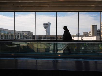 
A traveller moves in view of a control tower at Philadelphia International Airport in Philadelphia, Wednesday, November 5, 2025.