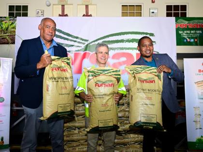 Minister of Agriculture, Fisheries and Mining, Floyd Green (right), shares in the symbolic handover of fertiliser by Newport-Fersan (Jamaica) Limited with the company’s Managing Director, Dennis Valdez (centre), and Chairman of the Agriculture Minist