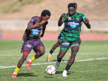 Kevaun Campbell (right) of Calabar High tries to keep up with a fast Shankeno Grant (left) of St Andrew Technical during a Manning Cup quarterfinal match at the Stadium East field on December 9.