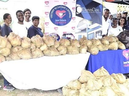 Janet Richards (right), founder of the Janet Richards Foundation, in a group shot with representatives from the Kingston-based law firm DunnCox during a handover of relief items to residents of Farm Heights, St James, last Thursday, following the passage o