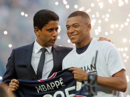 PSG President Nasser Al-Khelaifi, left, speaks to PSG's Kylian Mbappe as it is announced he has signed a three year extension to his contract, at the Parc des Princes stadium in Paris, France on May 21, 2022. 