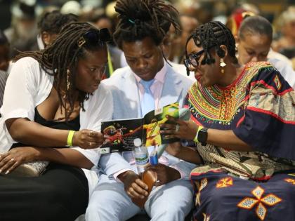 Some of Jimmy Chambers Cliff’s children, son Romeo Cliff and daughters Kadijah Cliff (left) and Odessa Chambers, take part in the music legend’s official funeral held yesterday at the National Indoors Sports Centre in Kingston.