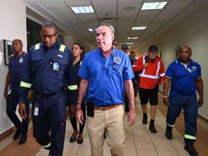 Hugh Grant (left), CEO of the Jamaica Public Service, and Energy Minister Daryl Vaz in discussion during the arrival of 117 linesmen from Canada at the Sangster International Airport in Montego Bay, St James, on Wednesday.