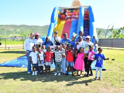 Sandals team members join children in Whitehouse, Westmoreland, for a photo at the Christmas treat on Thursday.