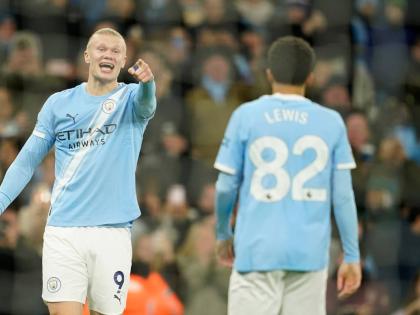 Manchester City's Erling Haaland, left, gestures to teammates Manchester City's Rico Lewis, as he celebrates after scoring his sides third goal of the game during the English Premier League football match between Manchester City and West Ham United in Manc