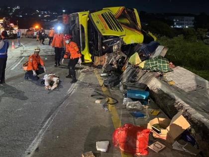 In this photo released by the Semarang Search and Rescue Office, rescuers tend to a victim of a deadly bus crash on a toll road in Semarang, Central Java, Indonesia, Monday, December 22, 2025. (Semarang SAR Office via AP)