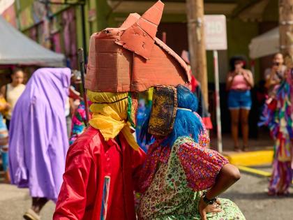 Jonkunnu characters Horse Head (left) and Belly Woman perform at the Sunday, December 21, Artwalk Festival Gran’ Market.