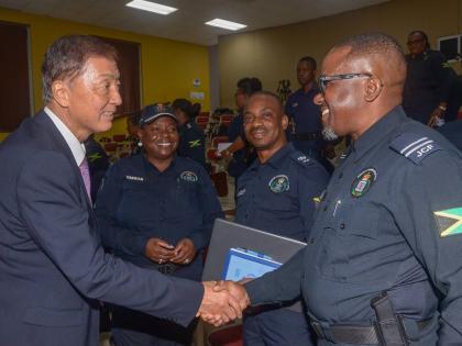 Ambassador of Japan to Jamaica, Yasuhiro Atsumi (left), greets Zonal Commander for the St Catherine North Police Division, Inspector Ismail Williams (right), at the closing-out ceremony for the Brazil-KOBAN community policing training programme, held at t