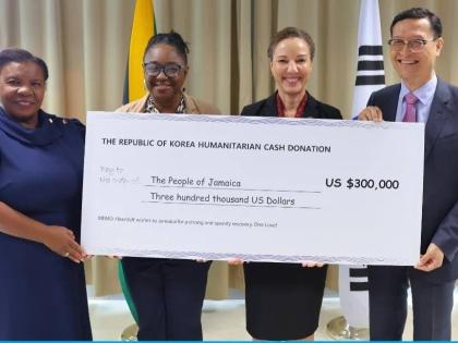 Minister of Foreign Affairs and Foreign Trade, Senator Kamina Johnson Smith (second right), receives a cheque valued at US$300,000 from Chargé d’Affaires at the Embassy of the Republic of Korea, Jin-wook Kim (right), to support Jamaica’s recovery and 