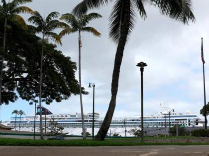 A cruise ship (in background) is docked in Honolulu, March 23, 2020.