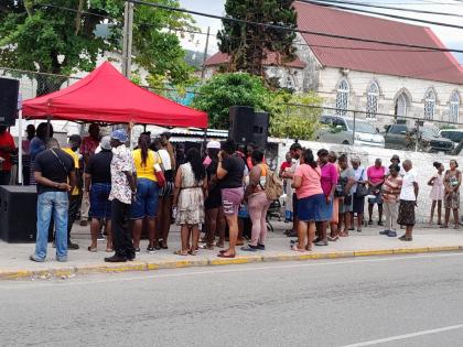 Passersby gather in the town square in Hopewell, Hanover, for the Jamaica Constabulary Force Community Praise and Worship.