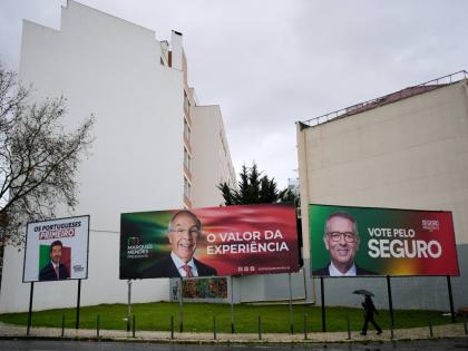 A person walks past presidential election campaign billboards for candidates André Ventura of Chega party, Luís Marques Mendes from Social Democratic Party and António José Seguro of Socialist Party, in Lisbon.