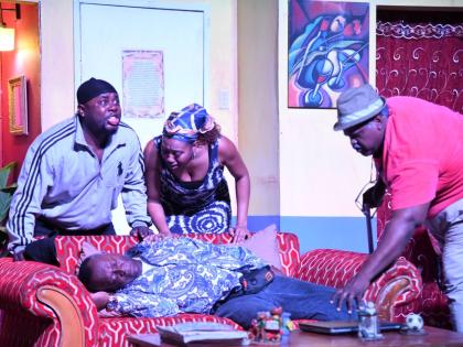 Glen Campbell, who plays Boopsie, faints after his wife Petal, played by Renae Williams (centre), explains to him that she lost the funds that he sent to her to build a house to a failed investment scheme. Her brother, Larry, played by Courtney Wilson (lef