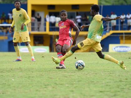 Montego Bay United’s Clarens Gilles (centre) is challenged by Treasure Beach FC’s Chandol Anderson during their Jamaica Premier League football game at St Elizabeth Technical High School on Sunday.