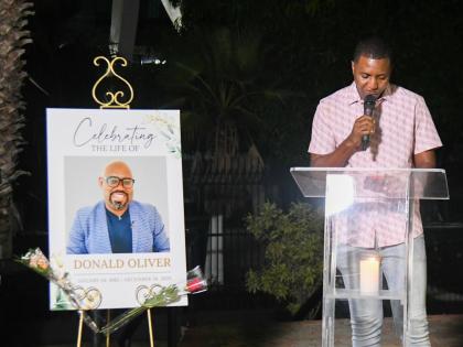 Sports journalist Ricardo Chambers reads an excerpt from Donald Oliver’s unpublished book at the Donald Oliver Candlelight Vigil held at Statue Park, National Stadium on Thursday night.