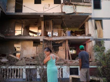 Residents look at a damaged apartment complex that neighbours say was hit during US strikes to capture Nicolás Maduro, in Catia La Mar, Venezuela.