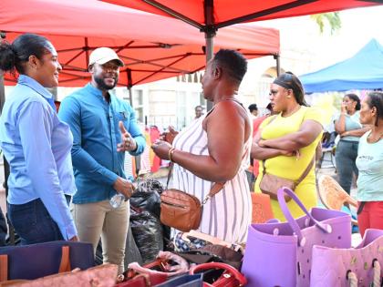 Mayor of Montego Bay and Chairman of the St James Municipal Corporation, Councillor Richard Vernon, along with Chief Executive Officer, Naudia Crosskill (left), engages vendor, Minorah Robinson (centre), and others during a visit with vendors across downto