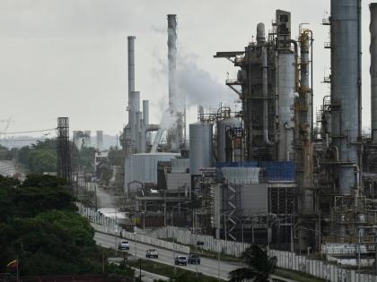 Vehicles drive past the El Palito oil refinery in Puerto Cabello, Venezuela.