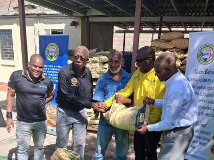 Chairman of the Jamaica Coffee Exporters Association (JCEA), Dr Norman Grant (4th left) inspects a bag of Newport Fersan fertiliser gifted to the association towards resuscitating coffee farms impacted by Hurricane Melissa. Also sharing in the occasion fro