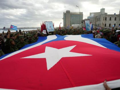 People carry a Cuban flag during a government-organized rally protesting the killing of Cuban officers in Venezuela while United States forces captured Venezuelan President Nicolas Maduro and his wife, in Havana, Cuba on January 16, 2026.