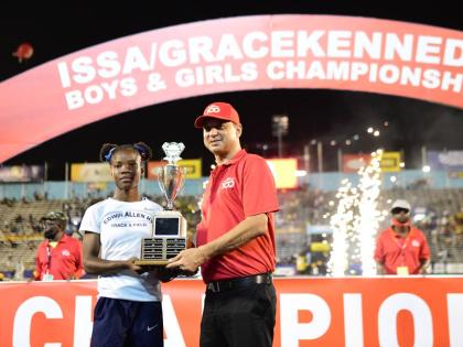 Edwin Allen’s Leanna Lewis (left) accepts the Girls’ Championship trophy presented by Don Wehby, group chief executive officer, GraceKennedy Group in 2022.