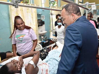 Dr Christopher Tufton, minister of health & wellness, speaks with Oshean Noble (left) and her daughter, Tiffany Campbell, during a tour of Ward 1 at the launch of the Family Caregivers Pilot Programme at the Bustamante Hospital for Children on Arthur Wint 