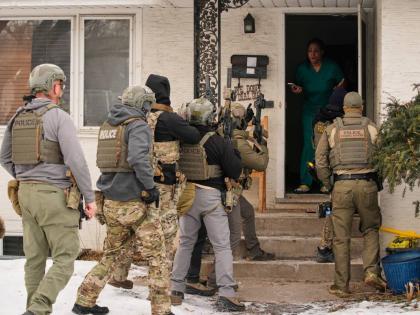 Teyana Gibson Brown, second from right, wife of Garrison Gibson, reacts after a federal immigration officer used a battering ram to break down a door before arresting Garrison Gibson Minneapolis. 