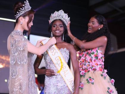 Former Miss Global Jamaica Keri-Ann Greenwood (right) passes the crown to Miss Global Jamaica 2026 Deidrian Downer (centre) at the Douglas Orane Auditorium at the Wolmers Boys’ School on Sunday morning. Fixing her sash is Miss Global 2025 Nhu Van.