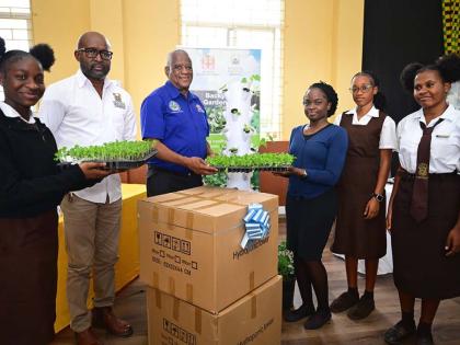 Minister of State in the Ministry of Agriculture, Fisheries and Mining, Franklyn Witter (third left), presents a vertical hydroponic tower to agricultural science teacher at Holmwood Technical High School Shania Wright (fourth left) during a ceremony held 