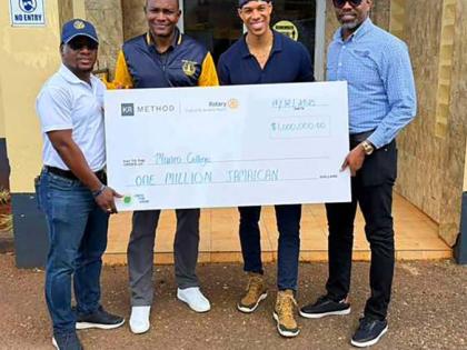 President of the Rotary Club of St Andrew North, Pierpont Wilson (left), hands over a cheque to Principal of Munro College, Dr Mark Smith (second left), at the school recently. Founder of KR Method, Korey Rowe (third left), and his brother, Past President 