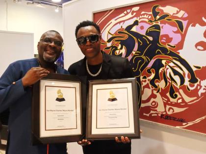 Wayne Wonder (right) and Kennedy Mensah of Back 2 Da Future Music Limited, showing off the Grammy certificates.