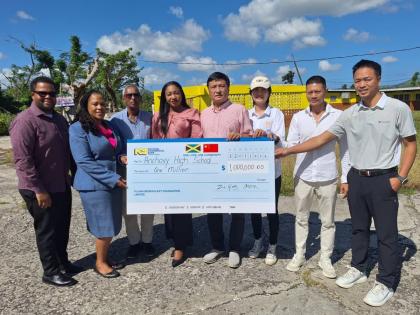 From left: Renardo Douglas, vice-chairman, Anchovy High School; Dr Lavern Stewart, principal; Nigel Goulab, chairman, accepting a symbolic cheque from members of the Chinese community in Montego Bay valued at $1 million from Ziping Chen, chairman of LCH De