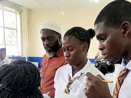 Manchester High physics teacher Christopher Taylor (left) looks on as his students (from right) Tonadria Branford, Jadan Hyatt and Nickacia Thompson prepare to conduct laboratory tests at the University of the West Indies (UWI) Department of Science and Te
