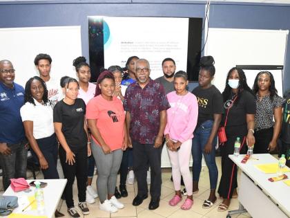Damion Hylton (left), project manager at Rise & Thrive, takes a group photo with participants at a youth workshop held recently at the Council of Voluntary Social Services office on South Camp Road in Kingston. 