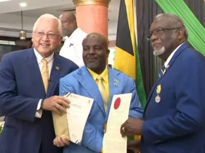 Justice and Constitutional Affairs Minister Delroy Chuck (left) and St James Custos Bishop Conrad Pitkin (right) present the commissioning documents and seal of justice of the peace (JP) to The Gleaner’s Albert Ferguson during a commissioning ceremony fo