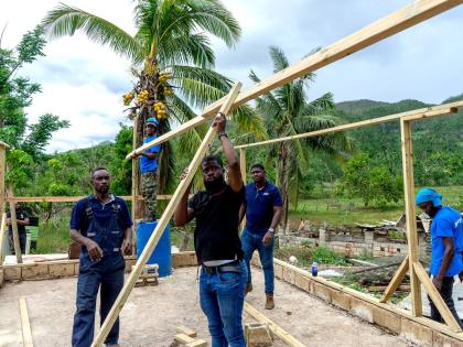 Nutramix Livestock Support Specialists Andre Williams (left) and Bruce Thomas (right), alongside Veterinarian Dr Gilbert Williams (centre), work to rebuild a chicken coop in St Elizabeth following the passage of Hurricane Melissa with support from teammate