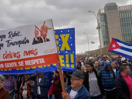 People holding a banner against President Donald Trump, march outside the U.S. Embassy to protest the killing of Cuban officers during the U.S. operation that captured Venezuelan President Nicolas Maduro, in Havana, Cuba, Friday, Jan. 16.