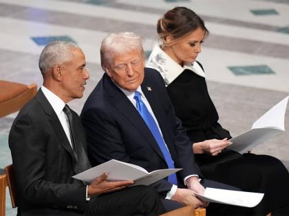 Former United States President Barack Obama talks with then President-elect Donald Trump as Melania Trump reads the funeral programme before the state funeral for former President Jimmy Carter at Washington National Cathedral in Washington on January 9, 20