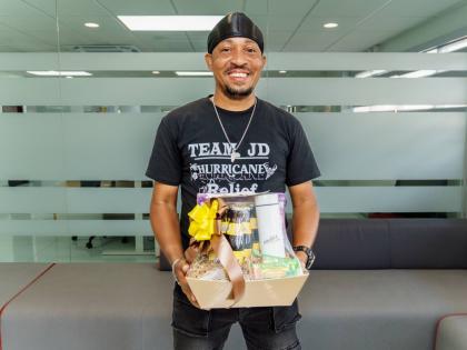 TikTok Creator Manawe Simpson smiles with his gift basket from Malta.