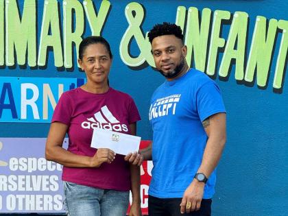 Novlette Moore (left) accepting M:FP C.A.R.E voucher, on behalf of a beneficiary, from Peter Ivey, founder of Mission: FoodPossible