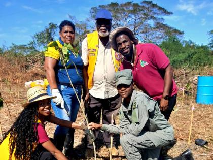 Andrew Hinds (right), forest manager at the Forestry Department (South East Region) joins volunteers from Jamaica 4-H Clubs, Jamaica Combined Cadet Force and Lions Club of Portmore for a photo moment after planting a tree in Innswood, St Catherine on Frida