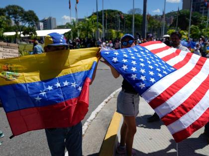 Demonstrators hold a Venezuelan and U.S. national flags during a student-led march calling for the release of people considered political prisoners on National Youth Day, in Caracas, Venezuela on February 12, 2026. 