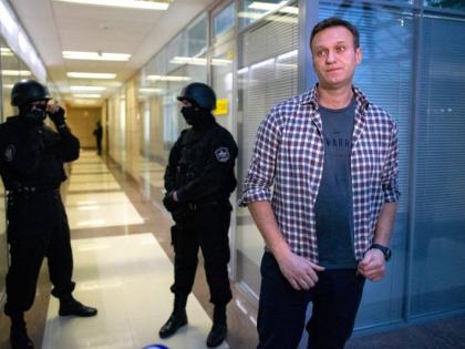 Former Russian opposition leader Alexei Navalny speaks to the media in front of security officers standing guard at the Foundation for Fighting Corruption office in Moscow, Russia on December 26, 2019.